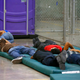 Young boys sleep in a holding cell.